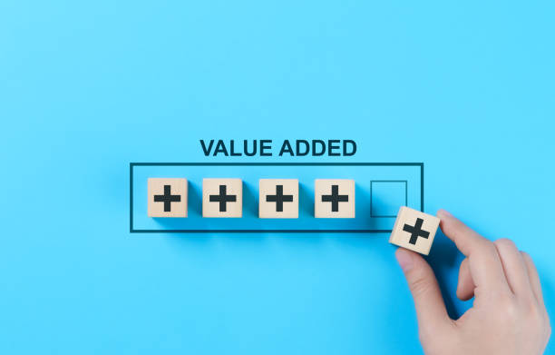 istock Value Added Concept. A hand arranging wooden blocks with plus signs Value Added representing growth, improvement, and added value in business and projects. Positive thinking or personal development, 2193865999
