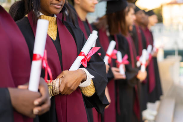 istock A line of ceremonial graduation scrolls held by graduates 2193866755