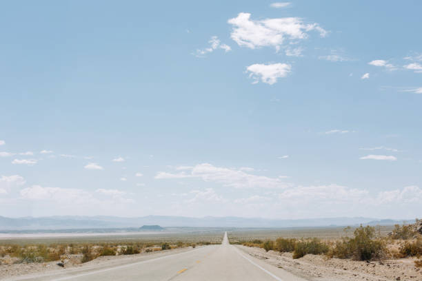 Panoramic view with an empty straight road in the desert, California.
