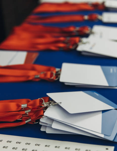 istock Process of checking in on conference congress forum event, registration desk table, visitors and attendees receiving lanyard with name badge and entry wristband bracelet and register electronic ticket 2193869714