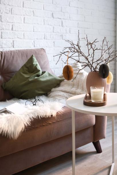 istock A beautifully cozy living room with modern easter home decor that includes vase with dry branches and eggs, notebook, glasses, ceramic rabbit, candles on coffee table. 2193871780
