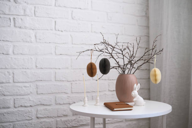 istock A beautifully cozy living room with modern easter home decor that includes vase with dry branches and eggs, notebook, glasses, ceramic rabbit, candles on coffee table. 2193871965