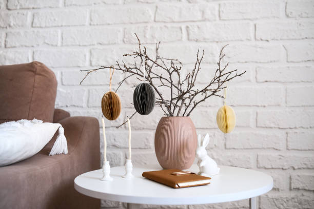istock A beautifully cozy living room with modern easter home decor that includes vase with dry branches and eggs, notebook, ceramic rabbit, candles on coffee table. 2193872257