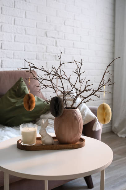 istock A beautifully cozy living room with modern easter home decor that includes vase with dry branches and eggs, ceramic rabbit, on coffee table. 2193872409