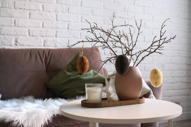 istock A beautifully cozy living room with modern easter home decor that includes vase with dry branches and eggs, ceramic rabbit,candle on coffee table. 2193872520