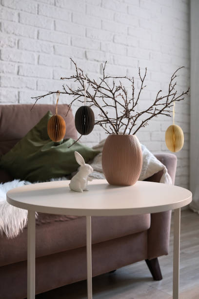 istock A beautifully cozy living room with modern easter home decor that includes vase with dry branches and eggs, ceramic rabbit, on coffee table. 2193872566