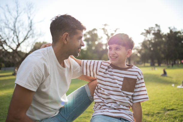 istock Father and son bonding outdoors on a sunny day in the park 2193874012