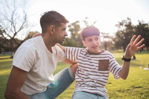 istock Father and son bonding outdoors in a sunny park setting 2193874020