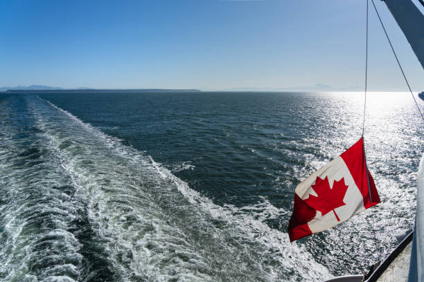 istock Ferry sailing on the ocean. Canadian flag and waves. 2193874303