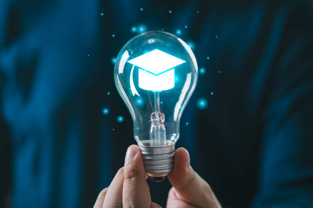 istock Hand holding glowing light bulb with graduation cap, symbolizing innovation and education in a creative concept illustration. 2193874559