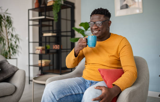 istock Cheerful man sips from blue mug in modern living area 2193878580