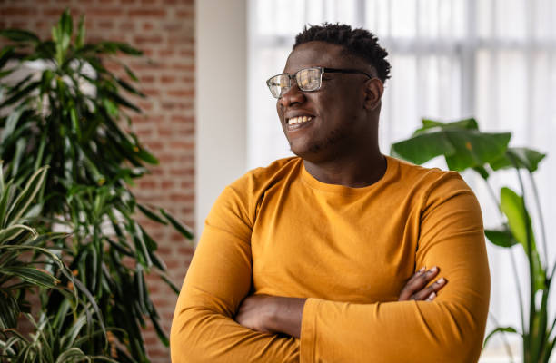 istock Man smiling in living room surrounded by green plants 2193880886