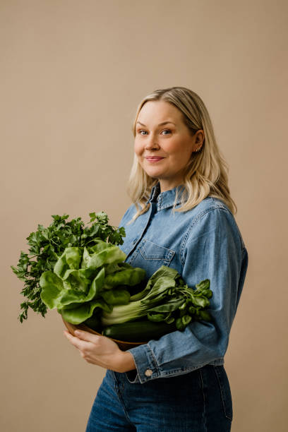 istock Woman in studio holding fresh healthy green vegetables 2193881004
