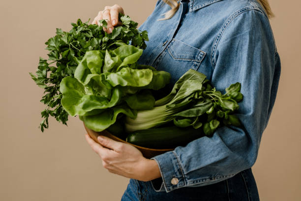 istock Woman in studio holding fresh healthy green vegetables 2193881053