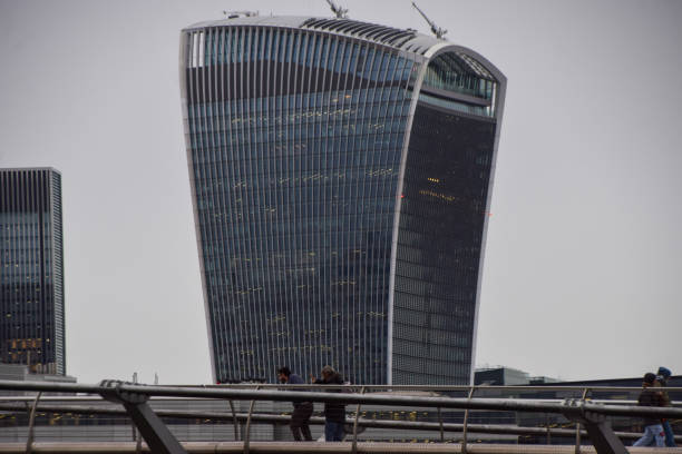 London, UK - December 23 2024: People walk along Millennium Bridge past the 20 Fenchurch Street tower, popularly known as the Walkie-Talkie Building.