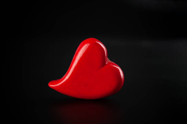 Red heart close up on a black background. Valentines day card