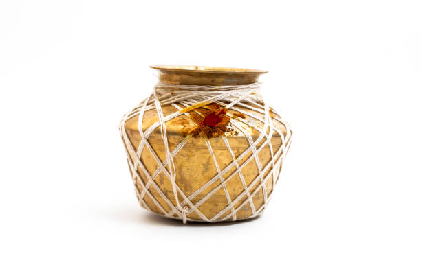 A traditional golden brass pot adorned with white strings and red ritual powder, isolated on a white background. Perfect for cultural, artistic, and heritage presentations.