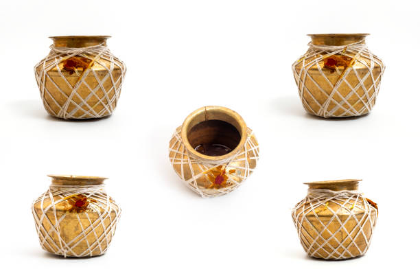 A traditional golden brass pot adorned with white strings and red ritual powder, isolated on a white background. Perfect for cultural, artistic, and heritage presentations.