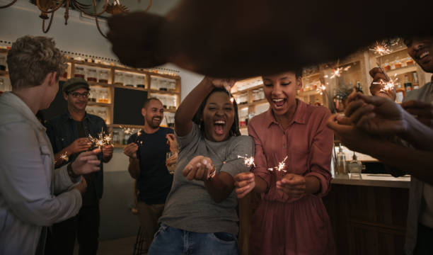 istock Laughing friends celebrating with sparklers together in a bar 2193889052