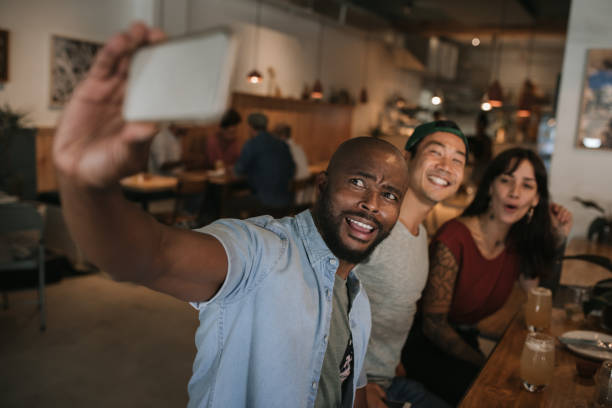 istock Smiling friends taking selfies together in a bar 2193889125