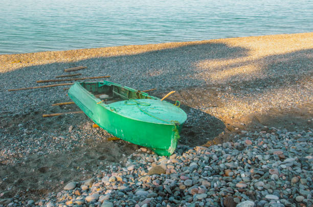 istock Abandoned Green Boat on Pebble Beach 2193889589