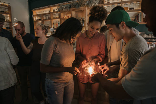 istock Smiling friends lighting sparklers while celebrating in a bar 2193889726