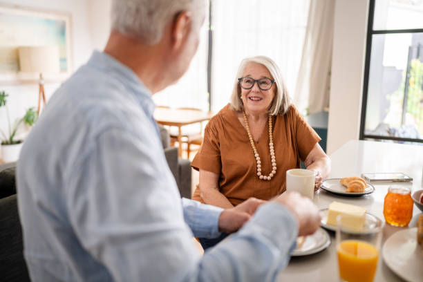 istock Smiling woman with coffee talks to partner over breakfast. 2193890427