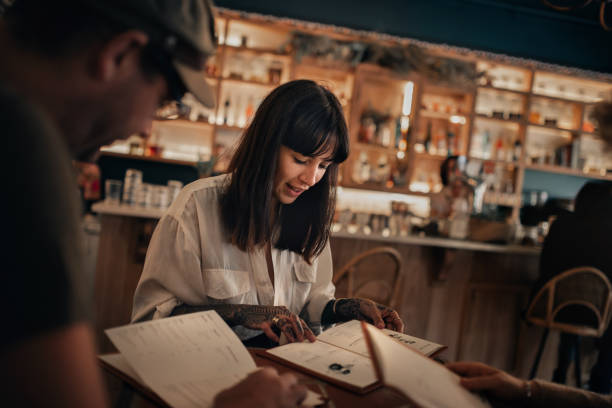 istock Friends reading drinks menus in a bar at night 2193891519