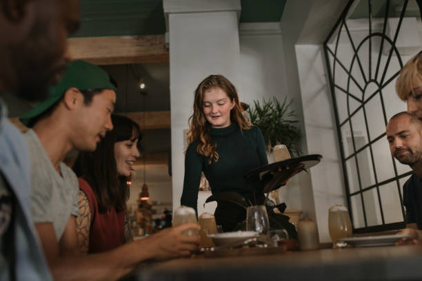 istock Waitress bringing customers drinks in a bar at night 2193891809
