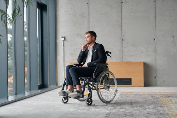 istock A director in a wheelchair sitting alone in an empty office, deeply reflecting on business strategies and decisions, contemplating the path forward with focused determination. 2193891832