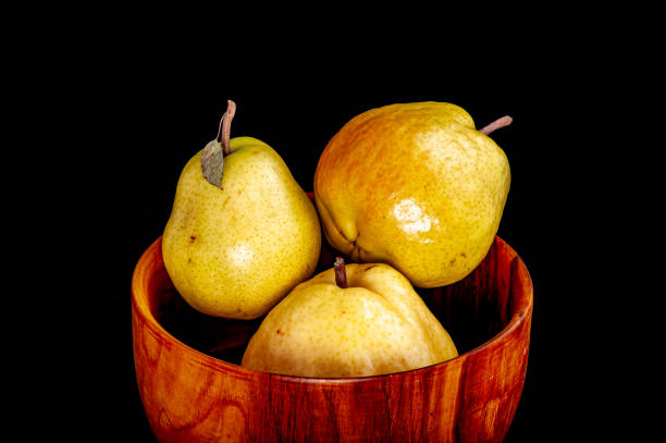 A bowl of pears on a black background