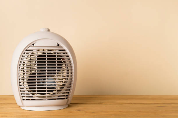 istock Portable electric heater on wooden table 2193893191