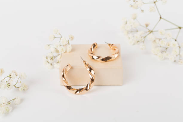 istock Golden earrings with decor on color background 2193893442