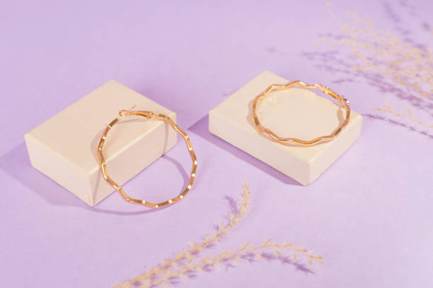 istock Golden earrings with decor on color background 2193893447