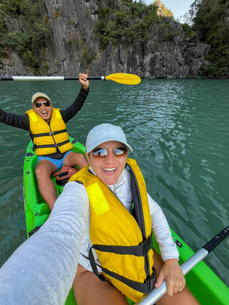 istock Adventurous couple kayaking on turquoise water surrounded by cliffs 2193895980