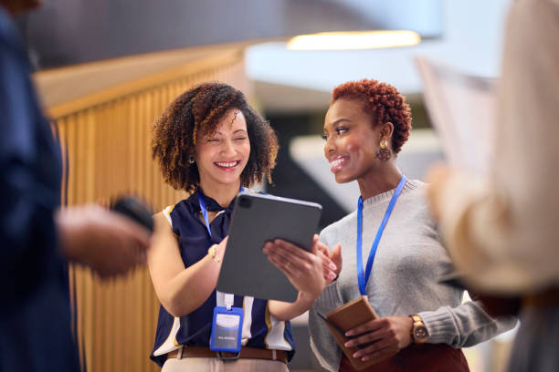 istock Smiling Colleagues Reviewing on Tablet at Conference 2193896124
