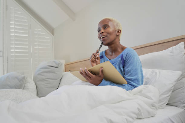 istock Woman with note pad sitting in bed 2193897239