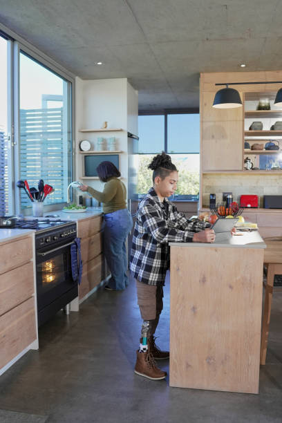 istock Boy with leg prosthesis preparing food in kitchen 2193897381