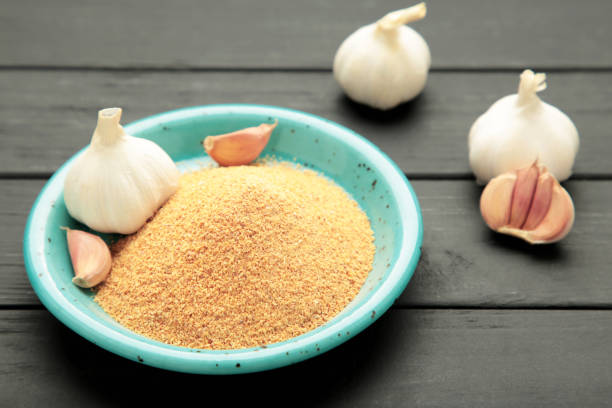 istock Garlic powder on plate on black wooden background, top view 2193900264