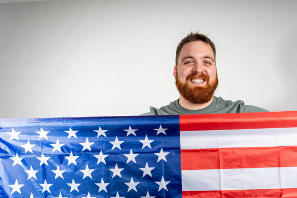 istock front view of happy smiling bearded man holding american flag isolated in studio 2193901068
