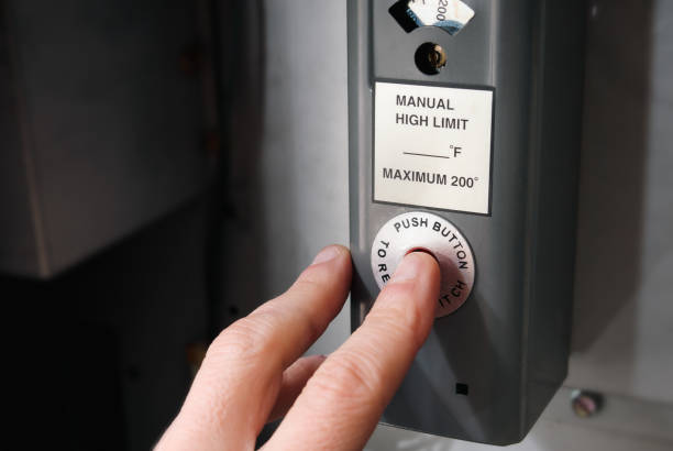 istock Person pushing reset button on hot water boiler. 2193902241
