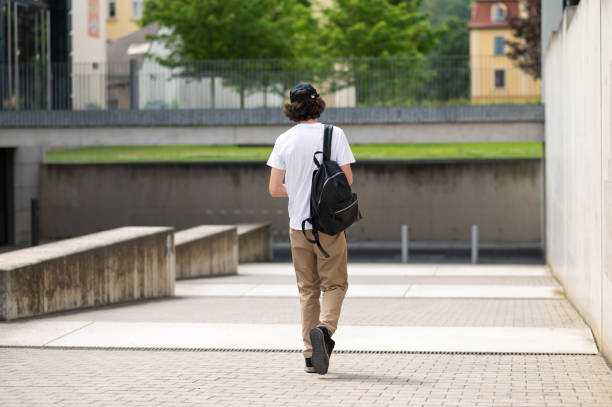 istock Tall dark-haired caucasian student with a backpack walking on the street 2193903169