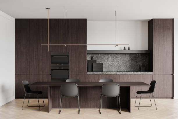 istock Modern kitchen interior with dark wood cabinetry, minimalist dining table, and sleek chairs. 3D Rendering 2193906259