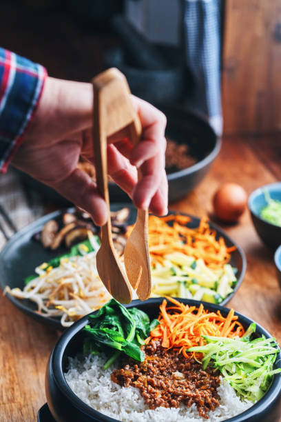 istock Preparing Bibimbap Korean Rice Dish in Domestic Kitchen 2193907527
