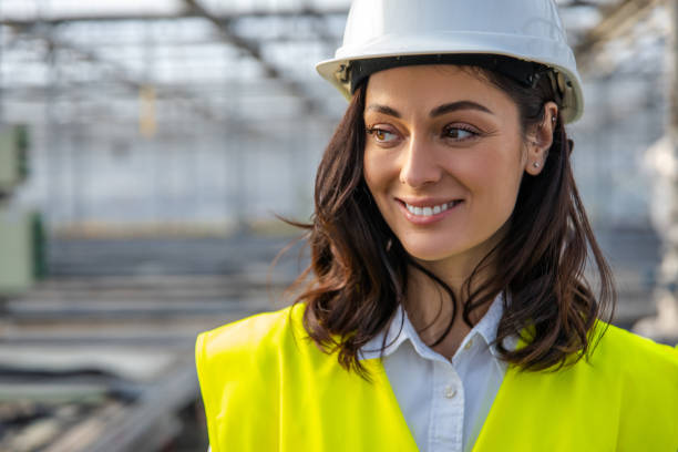 istock Smiling young female engineer in a hardhat and yellow vest 2193907607