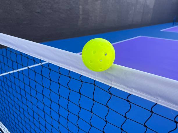 istock Yellow Pickleball ball passing close to the net 2193909030