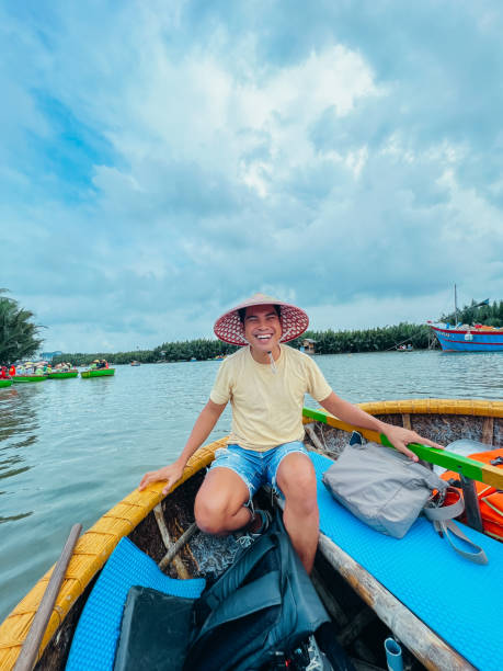 istock Man in Straw Hat Enjoying Boat Ride on Scenic River 2193909100