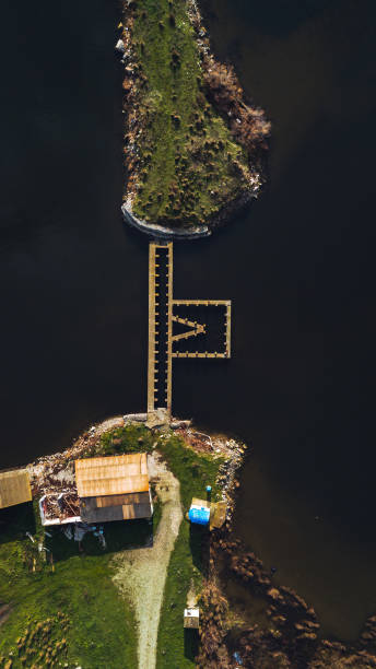 istock Aerial View of M Shaped Dock and Small Structures by Dark Water 2193909363