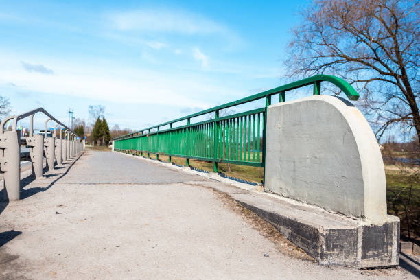 istock Pedestrian Bridge with Green Metal Railing and Concrete Base 2193911017