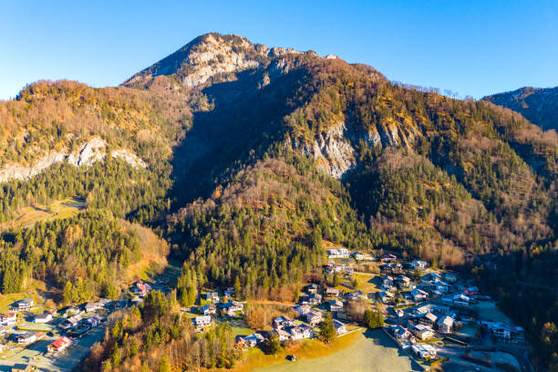 Aerial view of a small settlement at the foot of the mountain. Austrian Alps. The beginning of the winter season, first snow